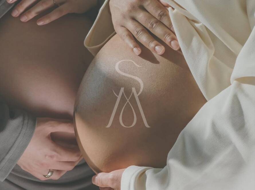 Dos mujeres embarazadas con las manos sobre el vientre, símbolo de calma y conexión en sesión de yoga prenatal.